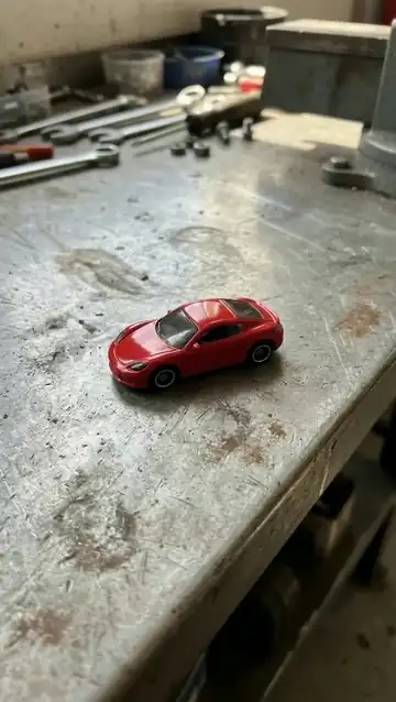 A hydraulic press descends and crushes the toy car flat